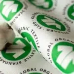 Cotton boll placed on labels showing Global Organic Textile Standard (GOTS) certification symbols.