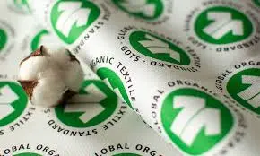 Cotton boll placed on labels showing Global Organic Textile Standard (GOTS) certification symbols.