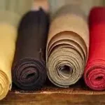 Rolled colorful fabric textiles representing GOTS-certified fabric dyeing and sustainable organic textile production