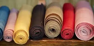 Rolled colorful fabric textiles representing GOTS-certified fabric dyeing and sustainable organic textile production