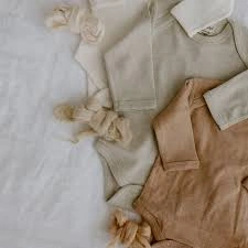 Organic cotton baby clothing and fabric essentials representing sustainable textile sourcing and ethical fashion production