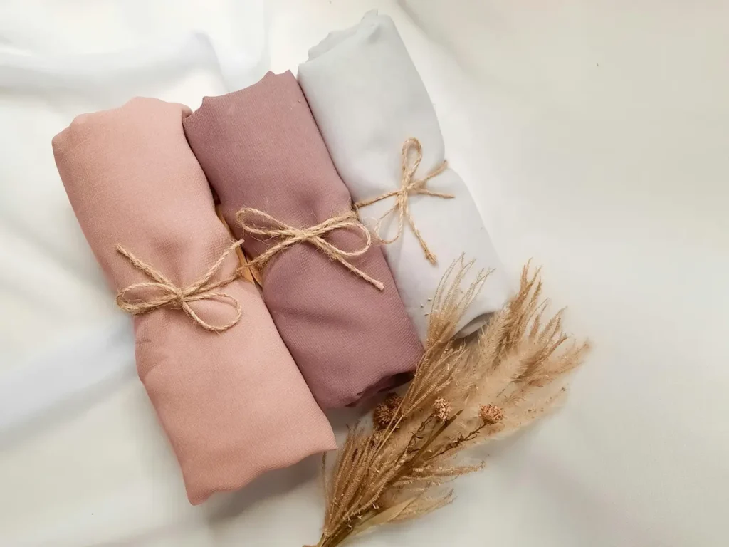 Rolled Tencel fabric bundles in soft neutral colors representing sustainable textile sourcing and eco-friendly fabric production