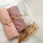 Rolled Tencel fabric bundles in soft neutral colors representing sustainable textile sourcing and eco-friendly fabric production